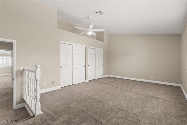 unfurnished bedroom with ceiling fan, high vaulted ceiling, carpet, and two closets