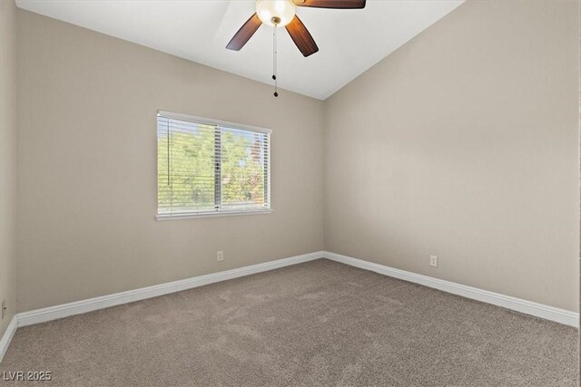 carpeted spare room featuring vaulted ceiling and ceiling fan