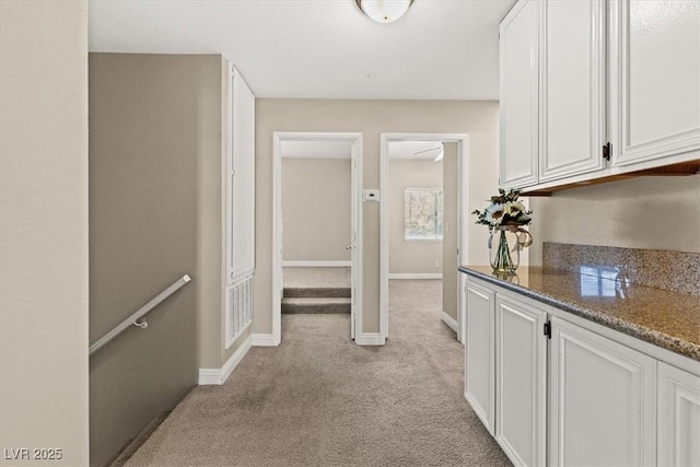 hall with light carpet and baseboards