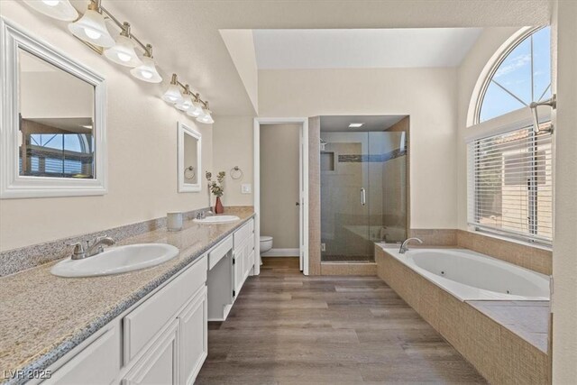 full bathroom featuring vanity, hardwood / wood-style flooring, independent shower and bath, and toilet