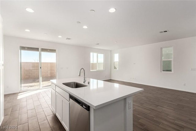 kitchen with a kitchen island with sink, sink, white cabinetry, and stainless steel dishwasher