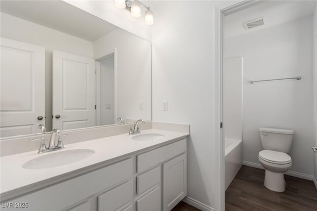 full bathroom featuring vanity, hardwood / wood-style floors, shower / tub combination, and toilet