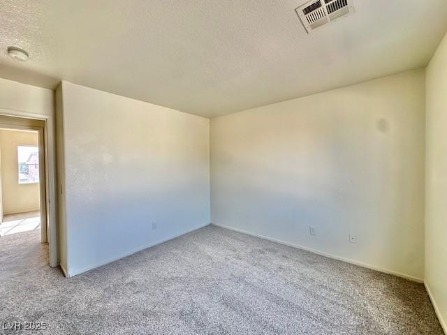 carpeted spare room featuring a textured ceiling