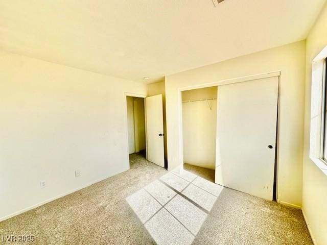 unfurnished bedroom featuring light colored carpet and a closet