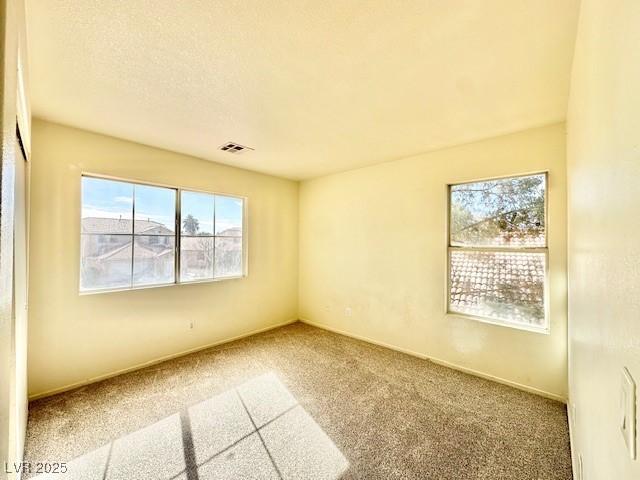 unfurnished room featuring carpet floors and a textured ceiling