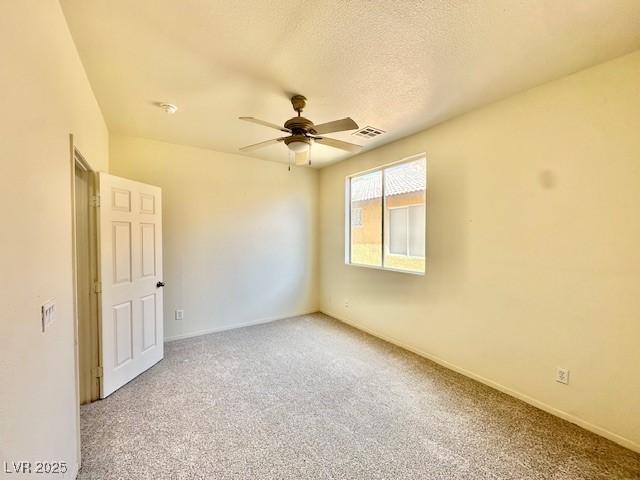 empty room featuring carpet floors, a textured ceiling, and ceiling fan