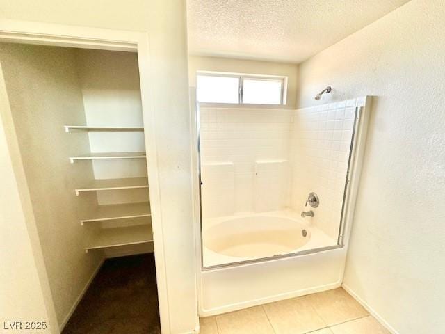 bathroom featuring bathing tub / shower combination, tile patterned floors, and a textured ceiling