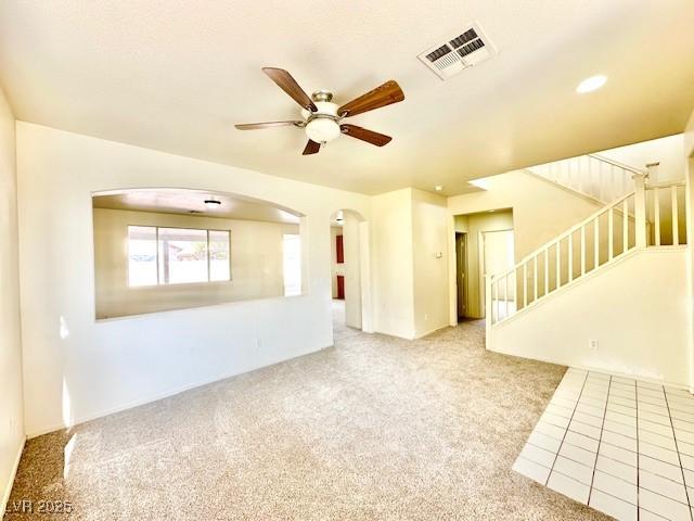 unfurnished living room featuring light carpet and ceiling fan