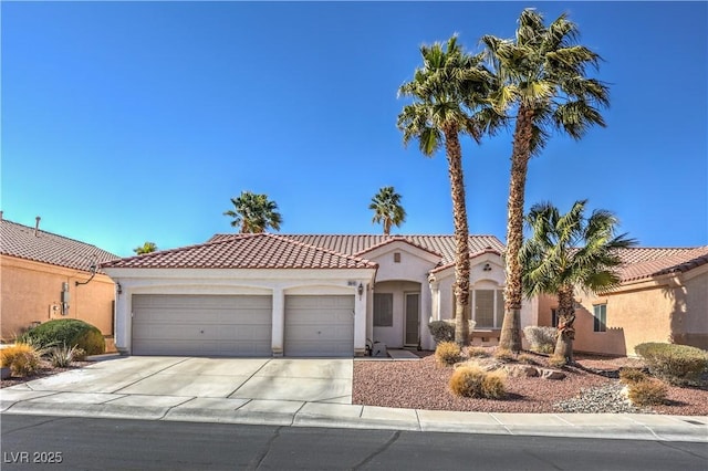 mediterranean / spanish home featuring stucco siding, an attached garage, a tile roof, and driveway