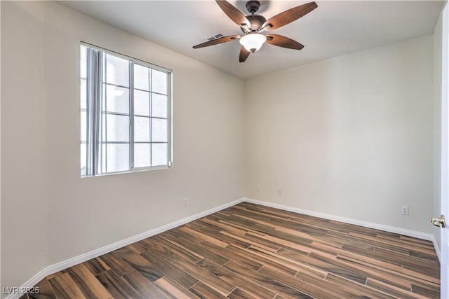 spare room featuring dark wood-type flooring and ceiling fan