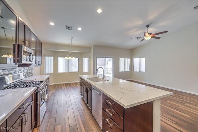 kitchen with a sink, dark wood finished floors, tasteful backsplash, and stainless steel appliances