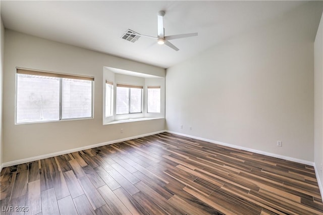 unfurnished room featuring a ceiling fan, dark wood-style floors, visible vents, and baseboards