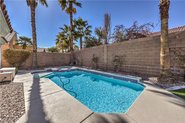 view of pool featuring a fenced backyard and a pool with connected hot tub