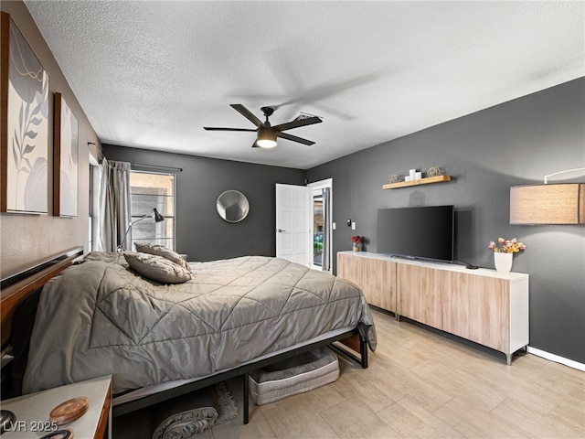 bedroom featuring ceiling fan, light hardwood / wood-style flooring, and a textured ceiling