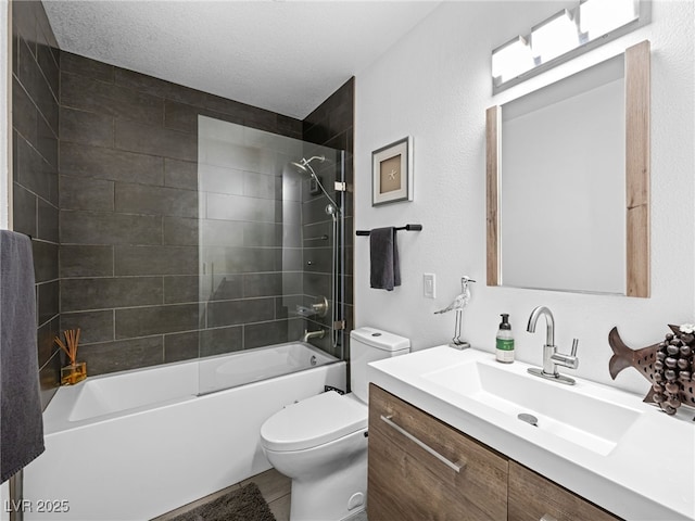 full bathroom featuring vanity, tiled shower / bath combo, a textured ceiling, and toilet