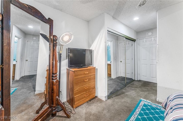 bedroom with a closet, carpet, and a textured ceiling