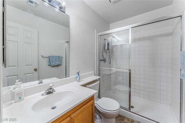 bathroom with walk in shower, vanity, and toilet