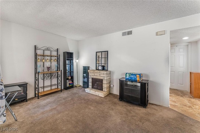 interior space with a fireplace, a textured ceiling, and carpet flooring