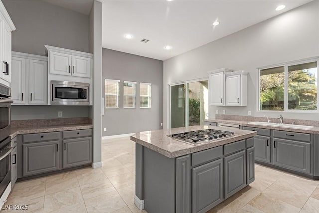 kitchen featuring sink, gray cabinets, white cabinets, and appliances with stainless steel finishes