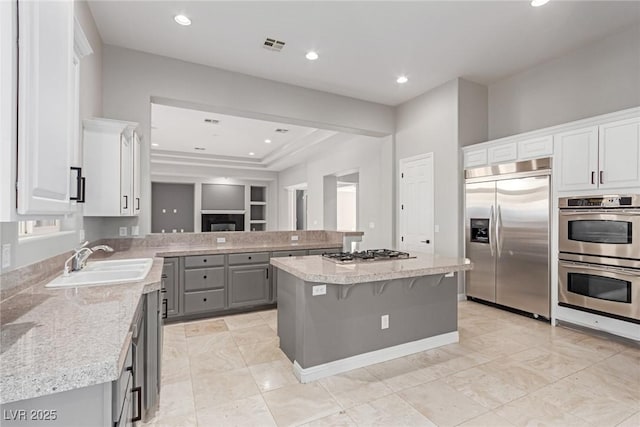 kitchen with sink, stainless steel appliances, a breakfast bar, and a kitchen island