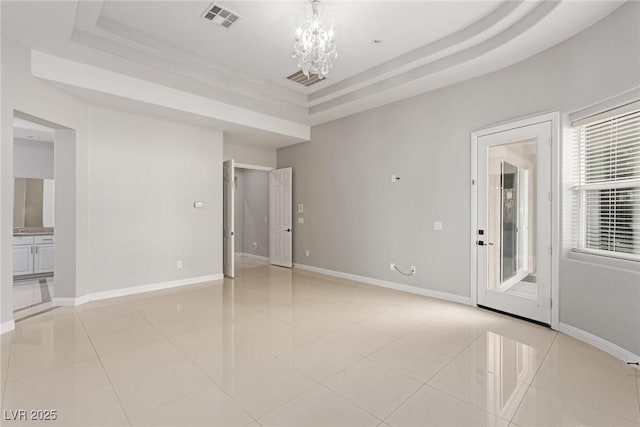 unfurnished room featuring light tile patterned floors, a notable chandelier, and a tray ceiling