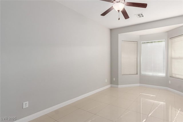 tiled empty room featuring ceiling fan