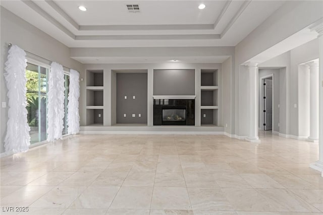 unfurnished living room with decorative columns, a raised ceiling, built in features, and a fireplace