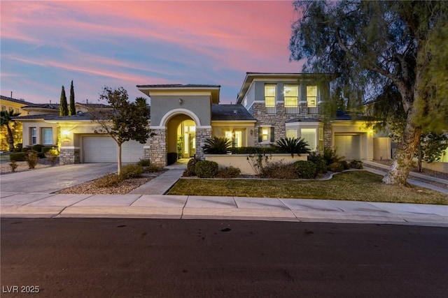 view of front of property with stone siding, an attached garage, driveway, and stucco siding