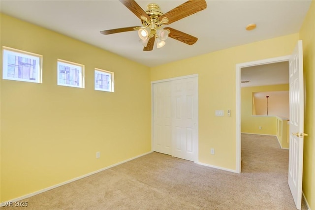 unfurnished bedroom featuring light carpet, a closet, and ceiling fan