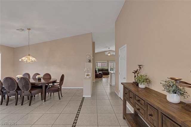 dining room featuring an inviting chandelier, light tile patterned floors, and vaulted ceiling