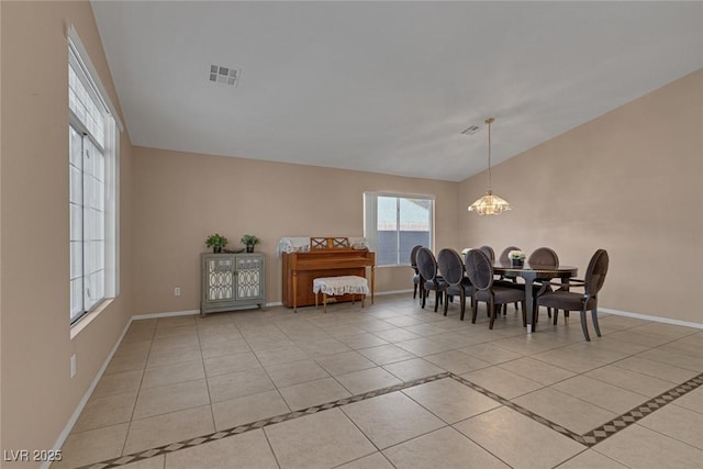 dining room featuring vaulted ceiling, light tile patterned floors, and a chandelier