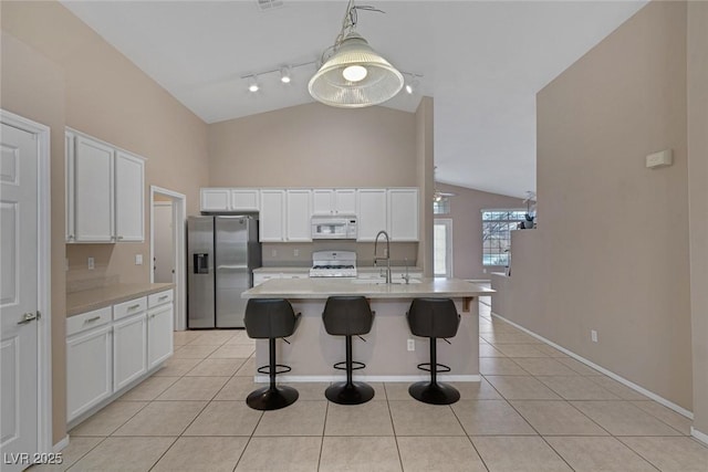 kitchen featuring sink, white appliances, light tile patterned floors, and white cabinets