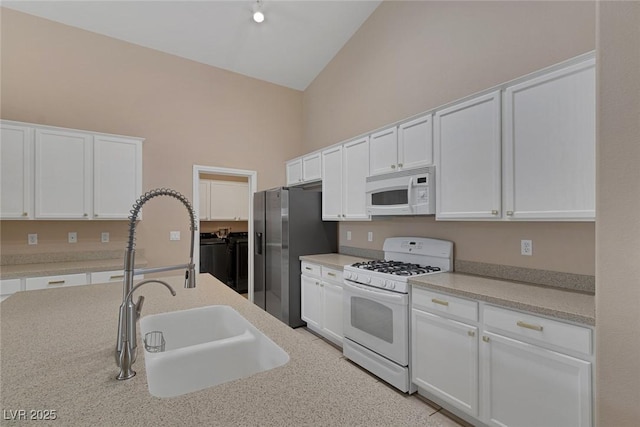 kitchen featuring white cabinetry, white appliances, and high vaulted ceiling