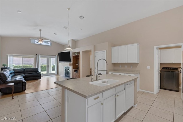 kitchen with sink, light tile patterned floors, white dishwasher, an island with sink, and white cabinets