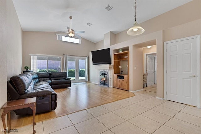 tiled living room featuring high vaulted ceiling and ceiling fan