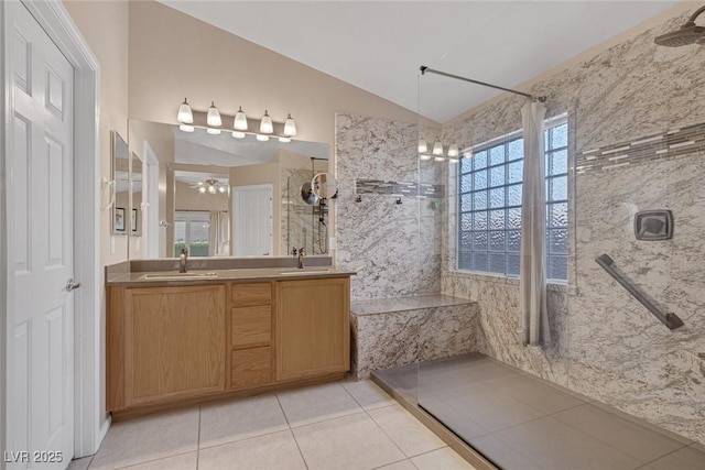 bathroom featuring tile patterned floors, tiled shower, lofted ceiling, and vanity