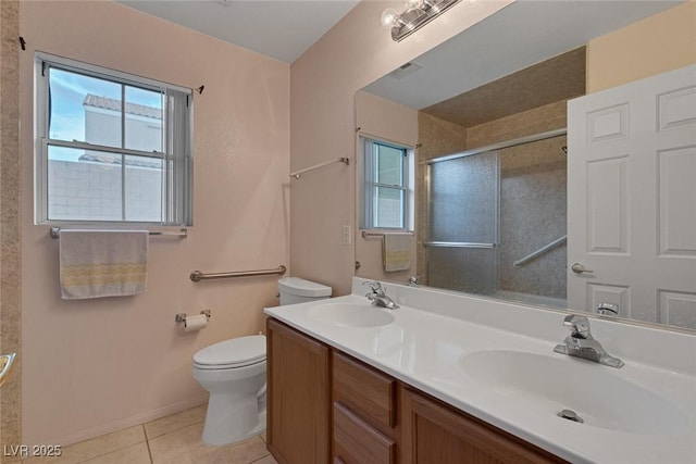 bathroom featuring toilet, a shower with shower door, tile patterned flooring, and a wealth of natural light