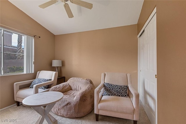 living area with vaulted ceiling, carpet flooring, and ceiling fan