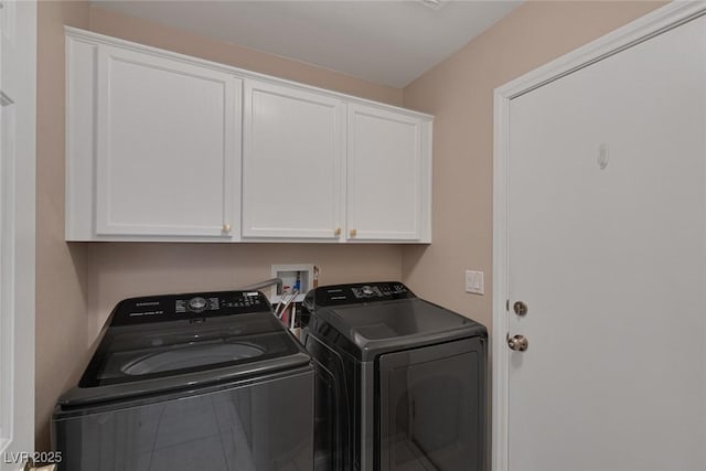 laundry area featuring washer and clothes dryer and cabinets