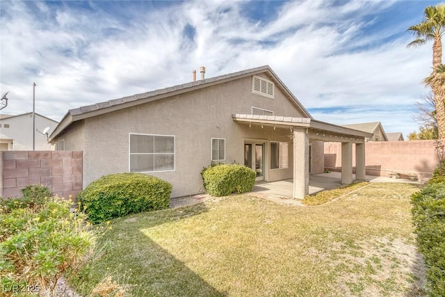 back of property with a patio and a yard