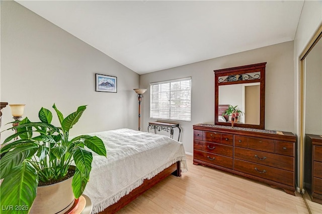 bedroom with lofted ceiling and light wood-type flooring