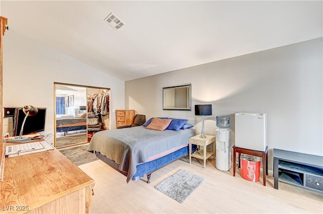 bedroom with vaulted ceiling and a closet