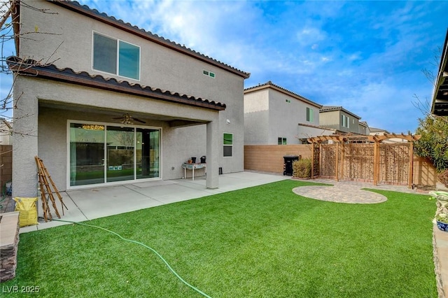 rear view of property featuring a yard, a pergola, a patio, and ceiling fan