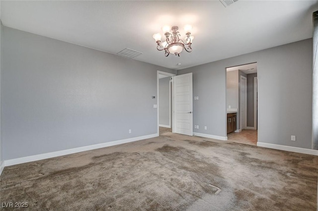 carpeted empty room featuring a notable chandelier