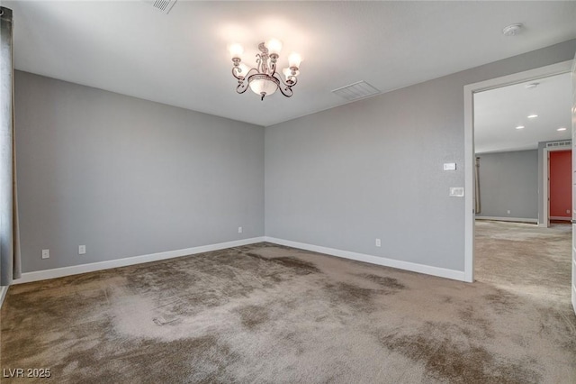 carpeted empty room with a notable chandelier