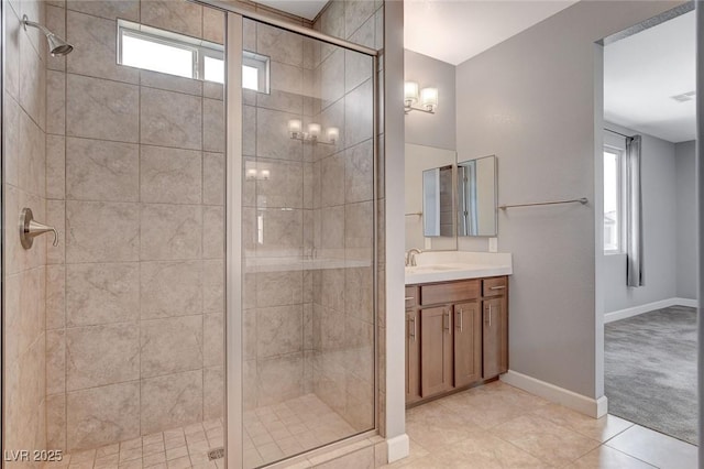 bathroom featuring vanity, a wealth of natural light, tile patterned floors, and a shower with shower door