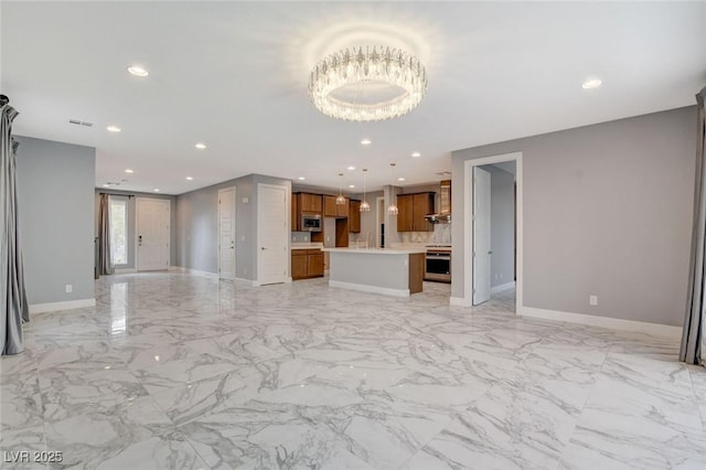 unfurnished living room featuring sink and an inviting chandelier