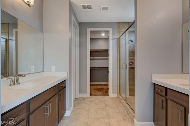 bathroom featuring tile patterned floors, vanity, and a shower with shower door