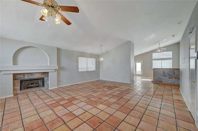 unfurnished living room with lofted ceiling, ceiling fan with notable chandelier, a fireplace, and light tile patterned flooring