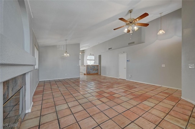 unfurnished living room featuring a tiled fireplace, vaulted ceiling, ceiling fan with notable chandelier, and light tile patterned flooring